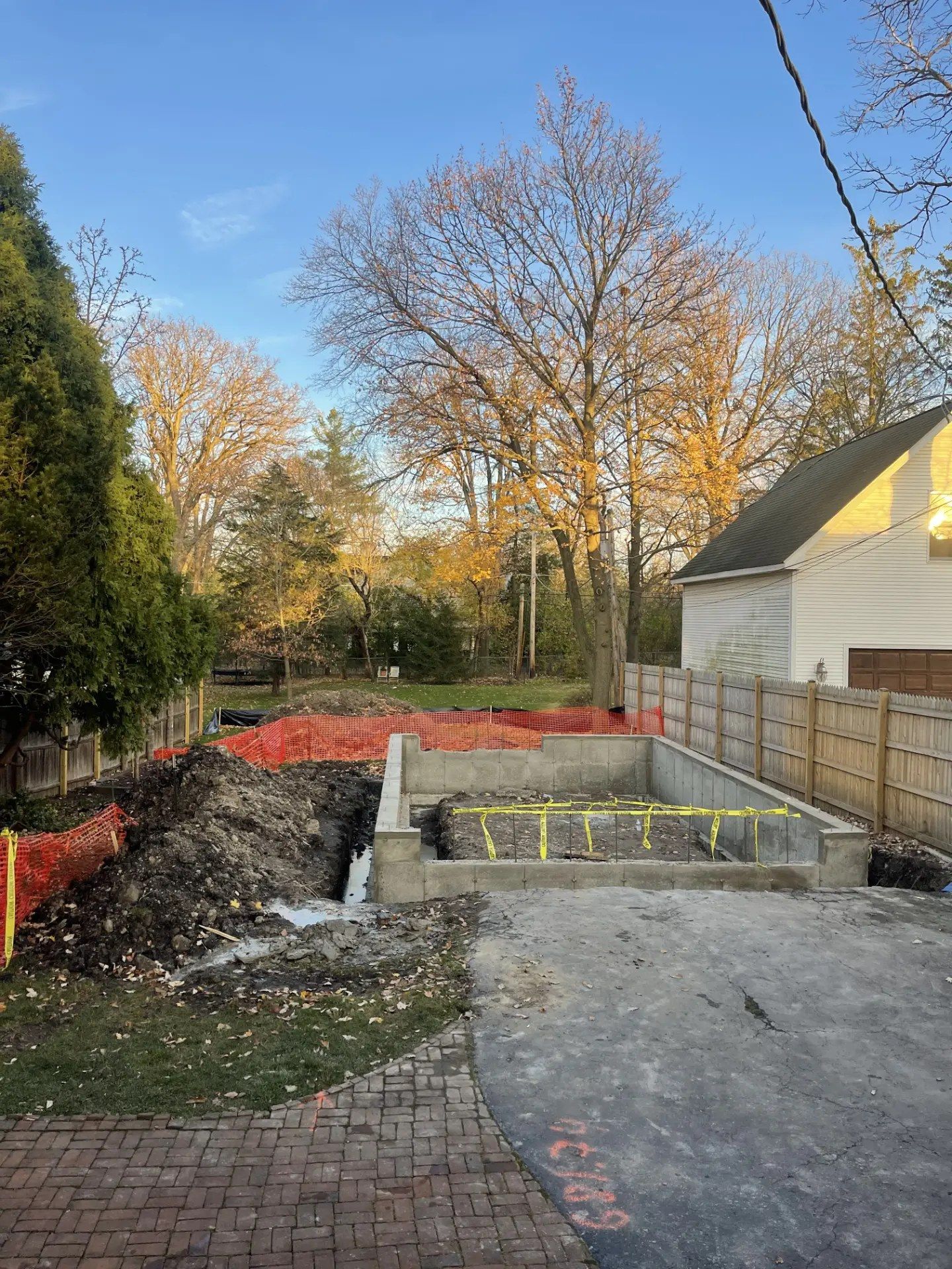 New concrete block foundation walls set in an excavated backyard